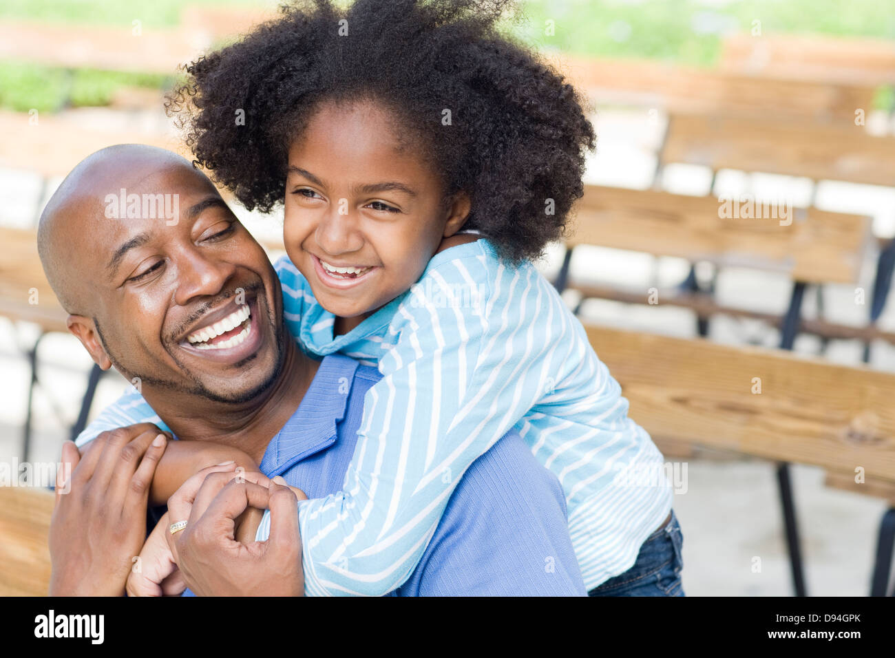 Vater und Tochter lächelnd auf Parkbank Stockfoto