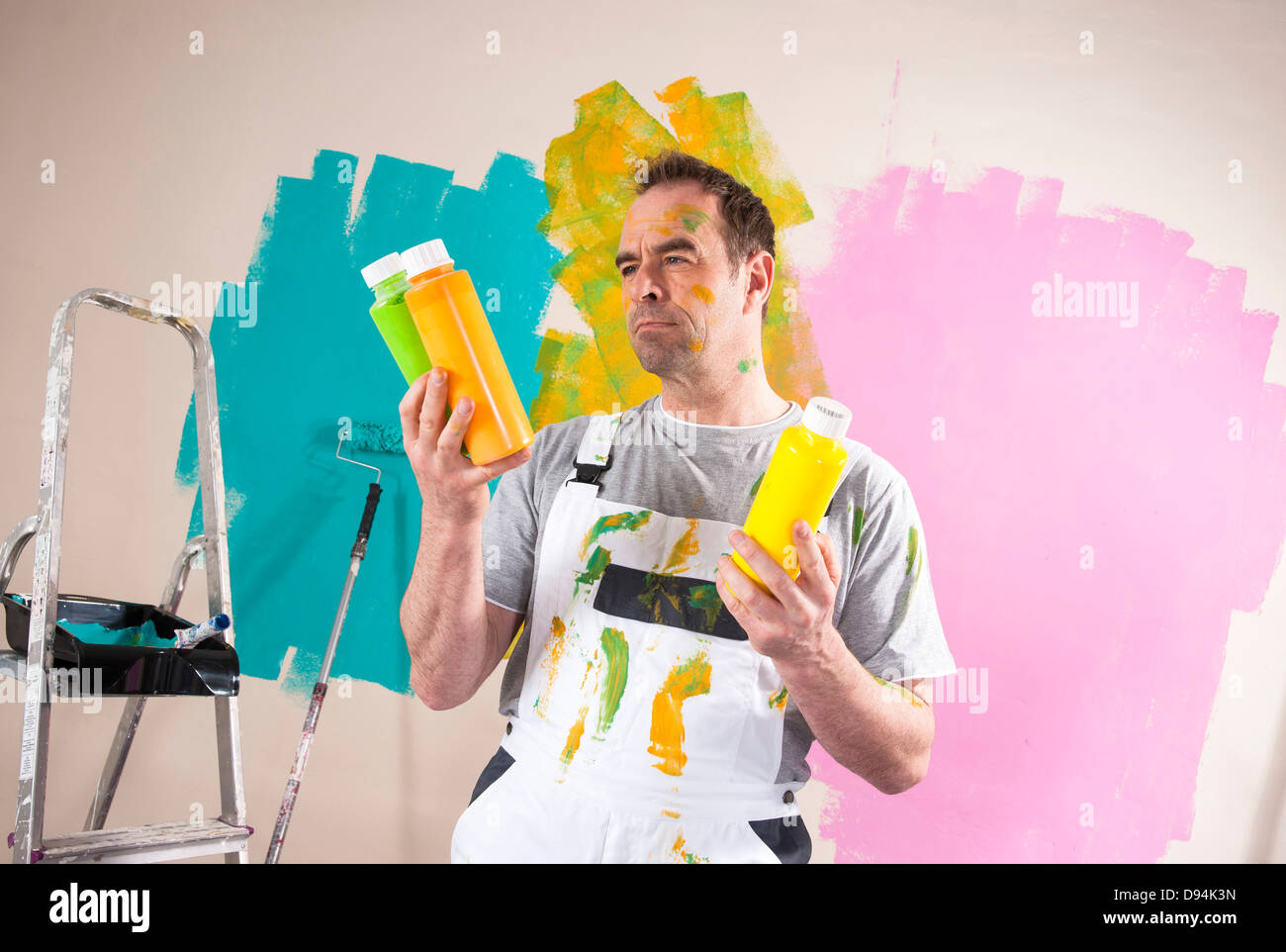 Reife Mann Renovierung seiner Wohnung und Entscheidung zwischen Lackfarben Stockfoto
