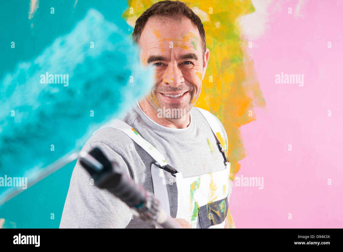 Porträt von reifer Mann mit Paint Roller Renovierung seiner Wohnung Stockfoto