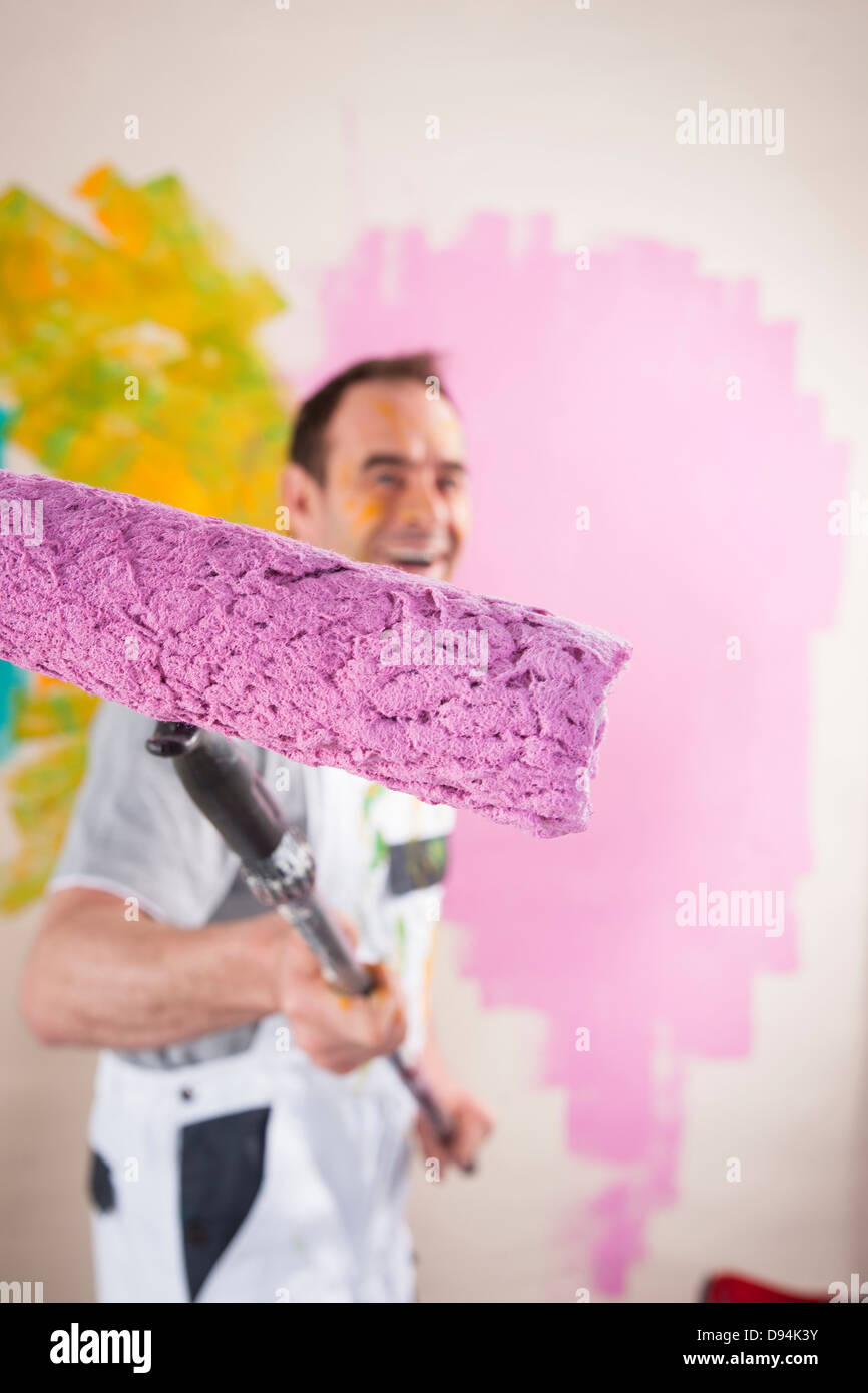 Porträt von reifer Mann mit Paint Roller Renovierung seiner Wohnung Stockfoto
