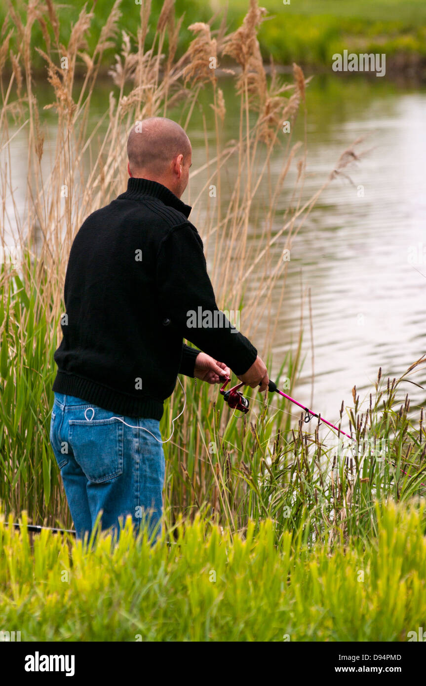 Angler Angeln an einem See mit Rute und Rolle Stockfoto