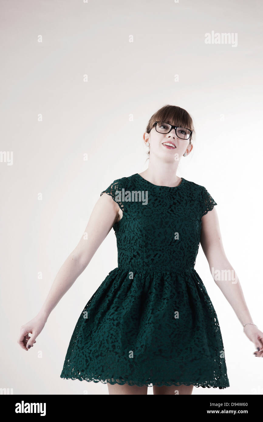 Porträt der jungen Frau trägt grün, Spitzenkleid und Horn-rimmed Brillen, auf der Suche nach oben, Studioaufnahme auf weißem Hintergrund Stockfoto