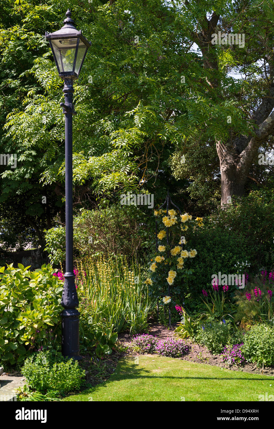 Sidmouth, Devon, England. Connaught Gärten. Viktorianischen Straßenlampen in einer Ecke des Gartens mit einem Rosenbusch. Stockfoto