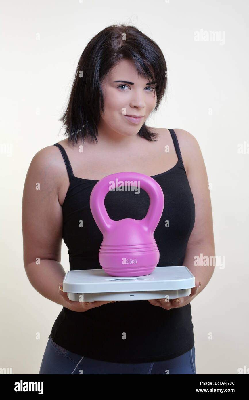 Konzept-Bild Modell Holding Skalen mit einer Kettlebell zeigt Ihnen, wie Shes gonna Verlust Gewicht und fit Stockfoto