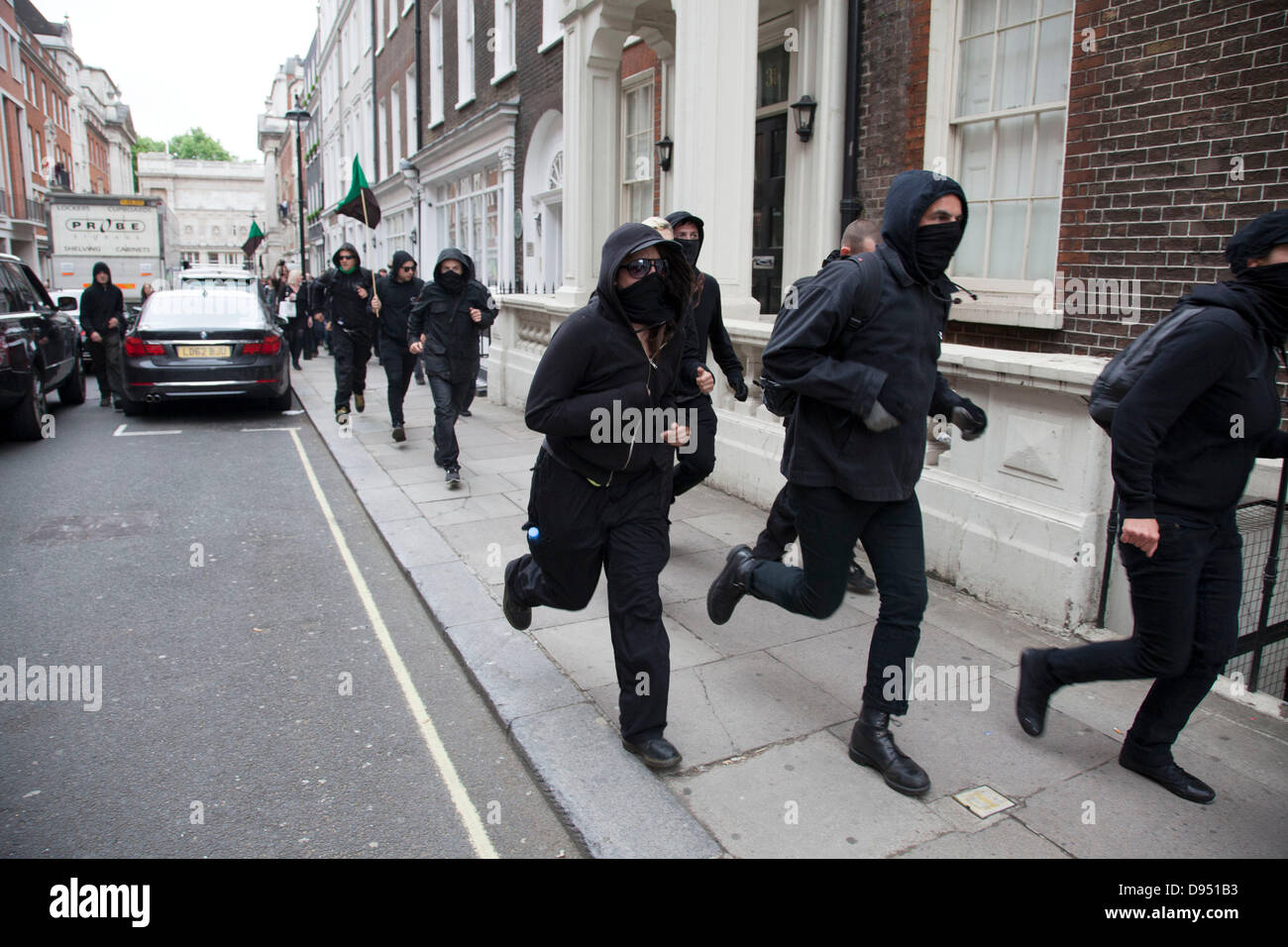 Anti-kapitalistischen Demonstranten durchlaufen einer Straße in Mayfair während der Demonstration gegen den bevorstehenden G8-Gipfel im Zentrum von London Stockfoto
