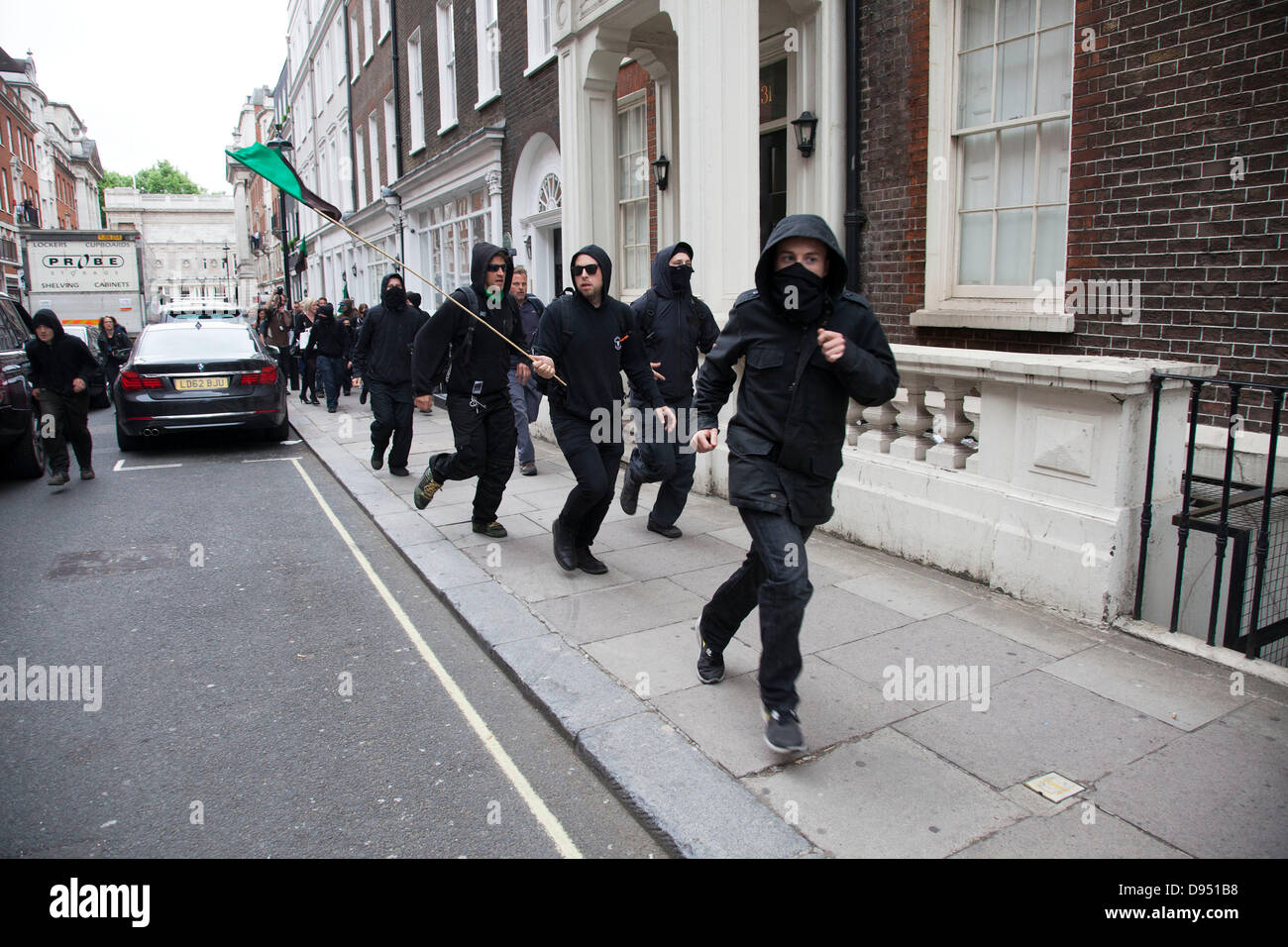 Anti-kapitalistischen Demonstranten durchlaufen einer Straße in Mayfair während der Demonstration gegen den bevorstehenden G8-Gipfel im Zentrum von London Stockfoto