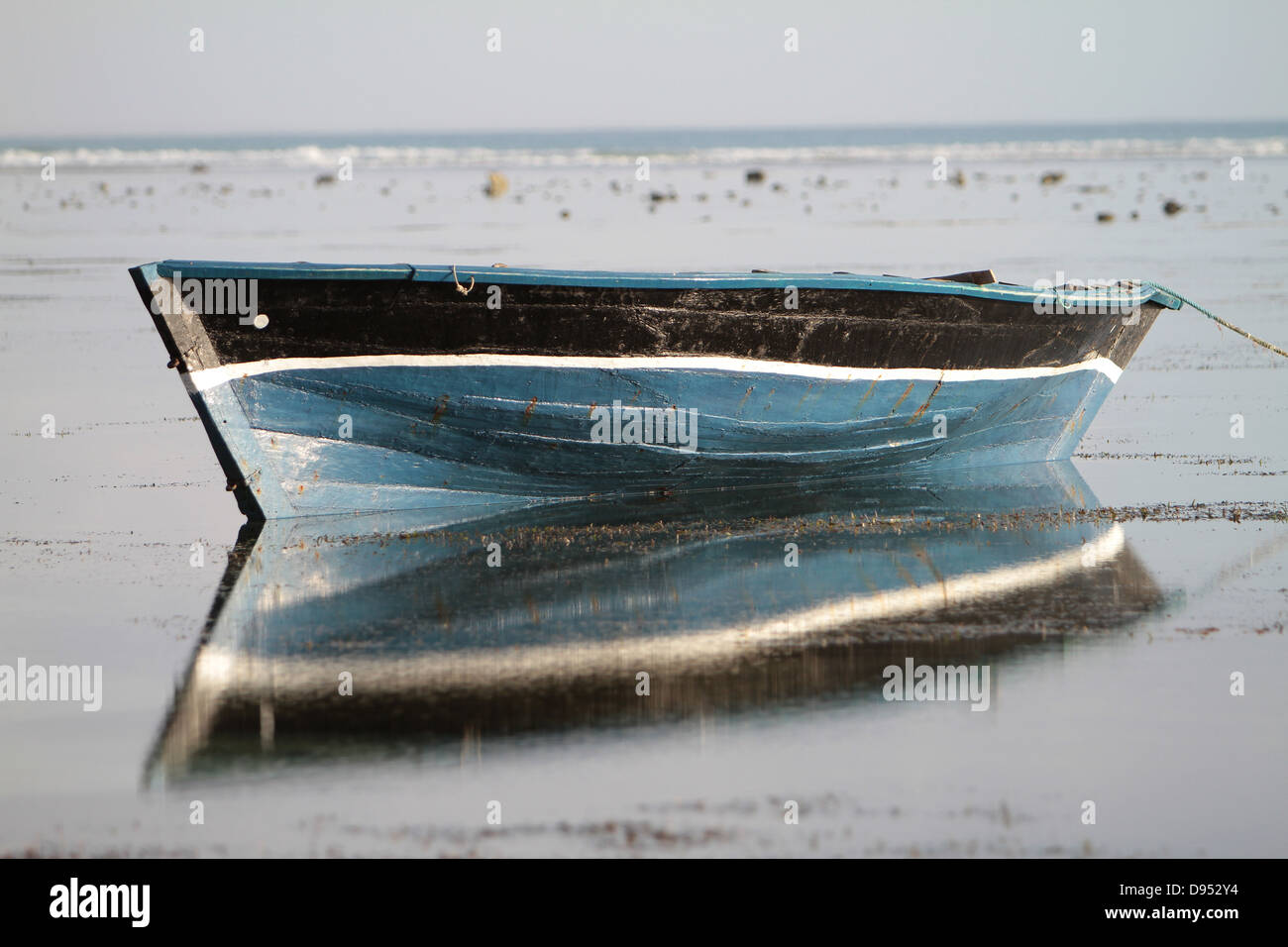eine blaue Dhau oder Angeln und Segelboot ruht in den flachen Gewässern des Ozeans Stockfoto