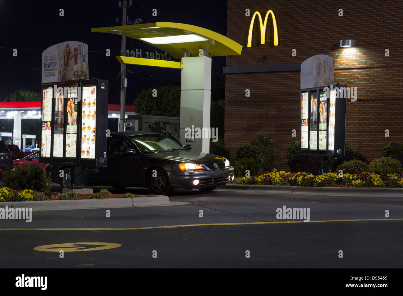 Automobile in Drive Thru Take Out-Lane und Fenster, McDonald's-Restaurant in der Nacht, USA Stockfoto