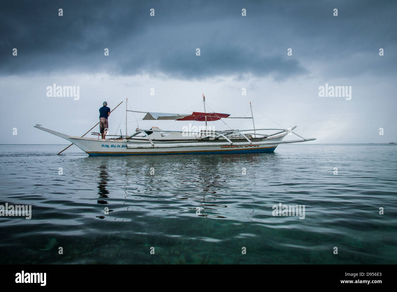 Fischer umstoßen traditionellen Auslegerboot flachen Meeren der Bounty Beach Malapascua Insel, in der Nähe von Cebu City, Philippinen Stockfoto