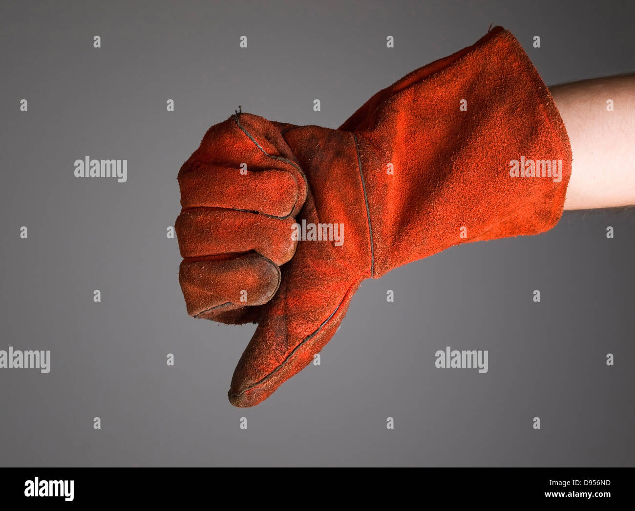 Hand mit dem Ausdruck Negativität mit Schweißer-Handschuh auf dunklem Hintergrund isoliert Stockfoto