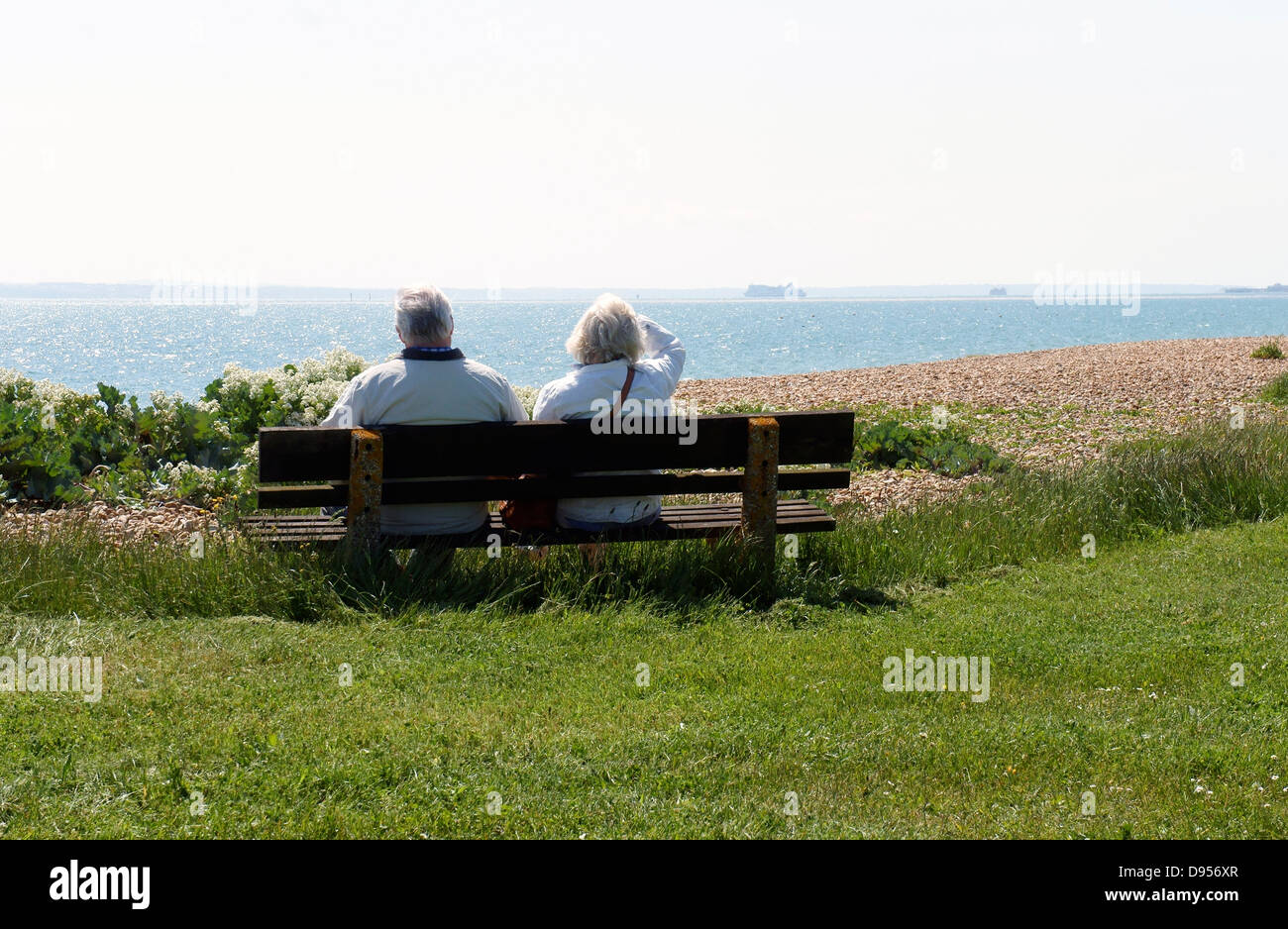 Senior Paar auf der Bank mit Blick auf das Meer, den Solent in Hayling Island Stockfoto