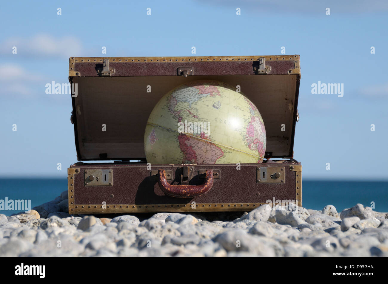 Globus in Koffer auf felsigen Strand, Frontignan, Herault, Frankreich Stockfoto