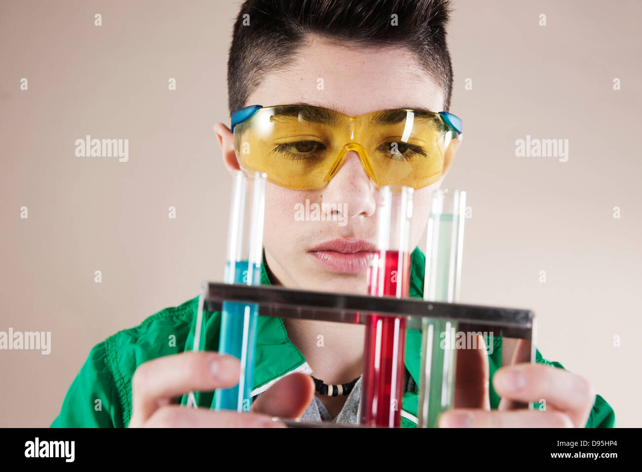 Jungen tragen Schutzbrille mit Reagenzgläsern des flüssigen, Mannheim, Baden-Württemberg, Deutschland Stockfoto