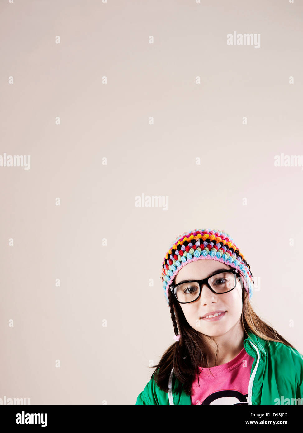 Porträt von Mädchen trägt Wollmütze und Horn-rimmed Brillen, lächelnd in die Kamera, Studioaufnahme Stockfoto