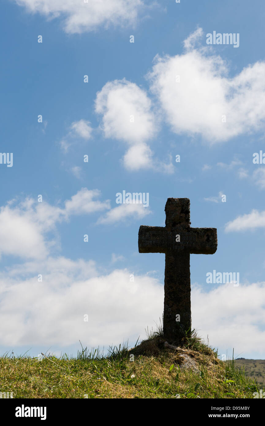 Grabstein Kreuz auf einer Bank des Grases. Silhouette. Kirche St. Pancras. Widecombe im Moor. Dartmoor, Devon, England Stockfoto