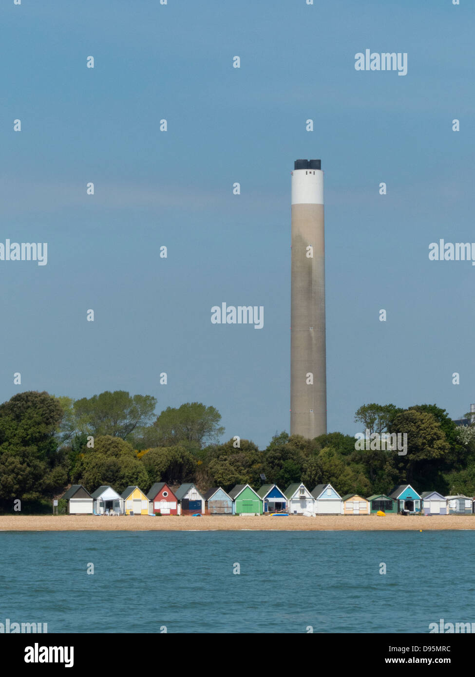 Fawley Befugnisse Station Schornstein hinter Luxus Strandhütten auf Calshot Strand Hampshire UK Stockfoto