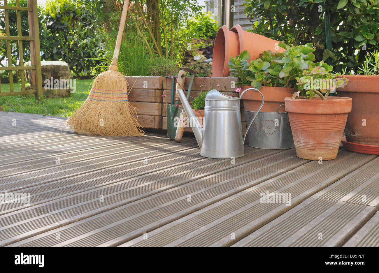 Diverses Zubehör für Gartenarbeit und Reinigung auf einem Holzdeck Stockfoto