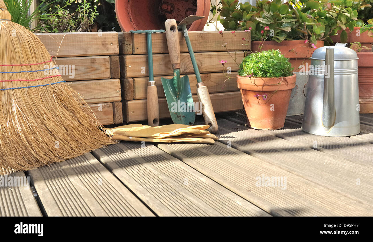 Diverses Zubehör für Gartenarbeit und Reinigung auf einem Holzdeck Stockfoto