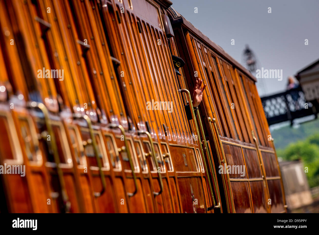 Der Bluebell Railway in East Sussex, UK. Eine Wache Wellen aus einem abfahrenden Zuges in Sheffield Park. Stockfoto