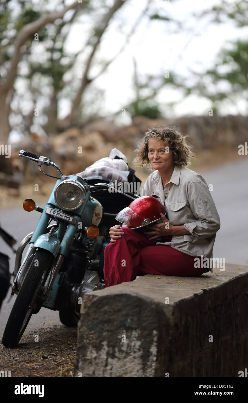 Europäerin mit einer Royal Enfield auf indischen Straßen Stockfoto