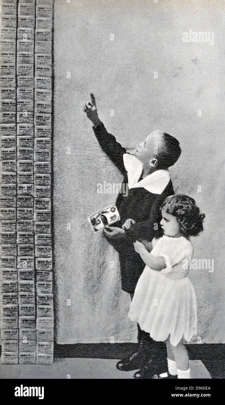 Die Hyperinflation in Deutschland nach dem Ersten Weltkrieg: Kinder auf der Suche nach einem ein Stapel von Tausenden von Dm, die nicht einmal wert sind die einzigen amerikanischen Dollar Bill, die der Junge hält. Stockfoto