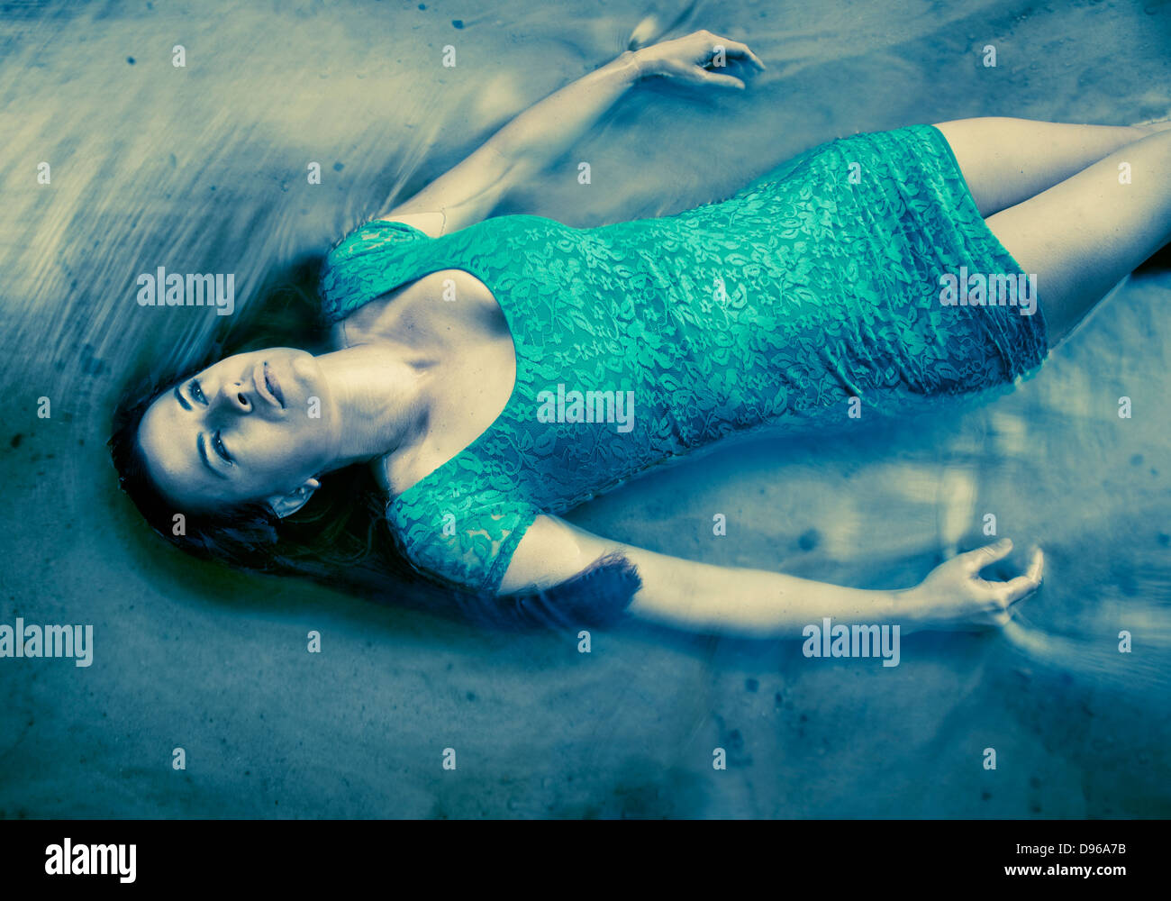 Frau im blauen Kleid, die im Wasser schweben Stockfoto
