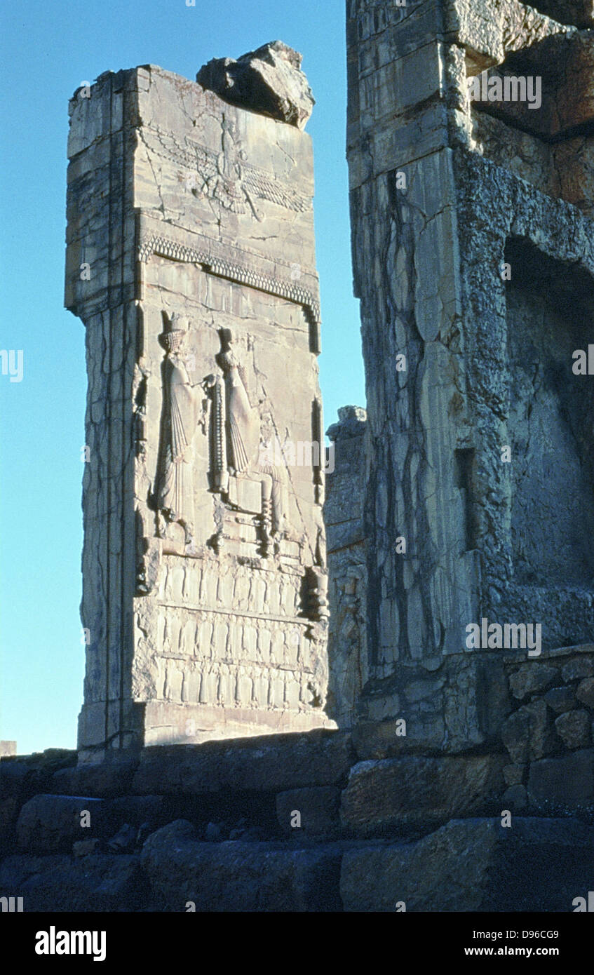 Sitzende Figur des Königs mit dem Knecht, der unter den geflügelten Symbol des Ahura Mazda, verehrt von der Zoroastrier. Persepolis: Königliche Audienzhalle des Darius, ca. 500 v. Chr. Stockfoto