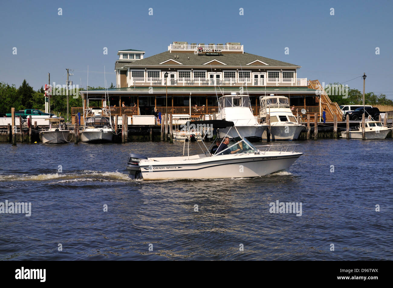 Kleines Boot Reißverschlüsse von angedockten Schiffe und Irish Eyes Restaurant am Hafen von Lewes, Lewes Delaware Stockfoto