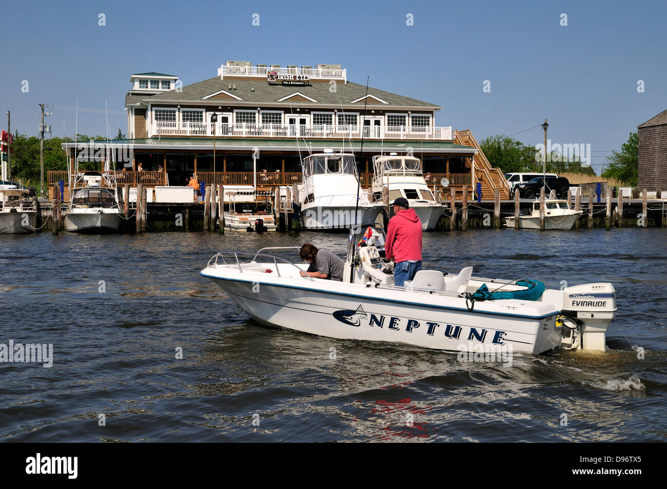 Kleines Boot Reißverschlüsse von angedockten Schiffe und Irish Eyes Restaurant am Hafen von Lewes, Lewes Delaware Stockfoto