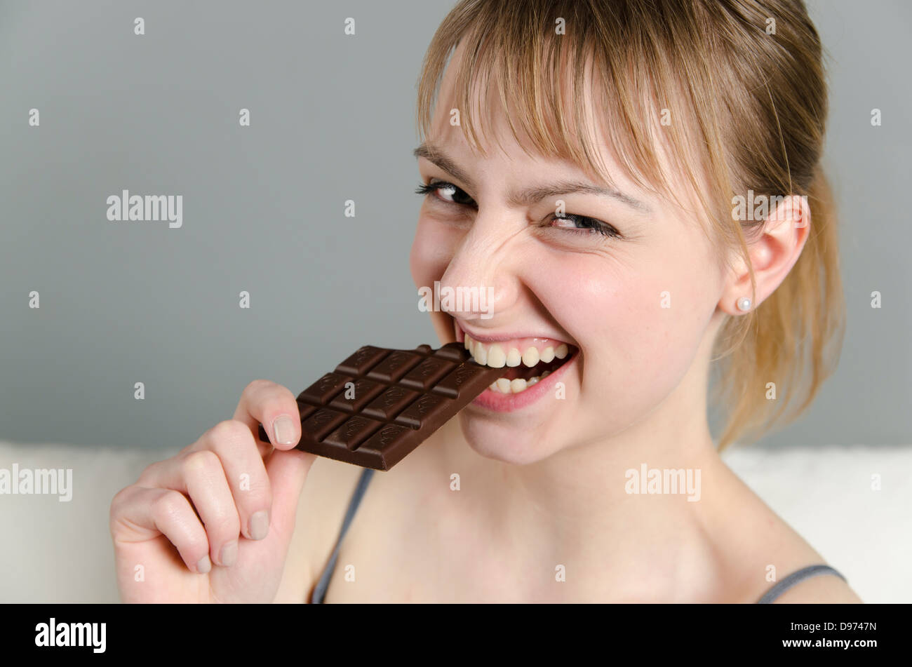 Porträt der jungen Frau essen Schokolade, Lächeln Stockfoto