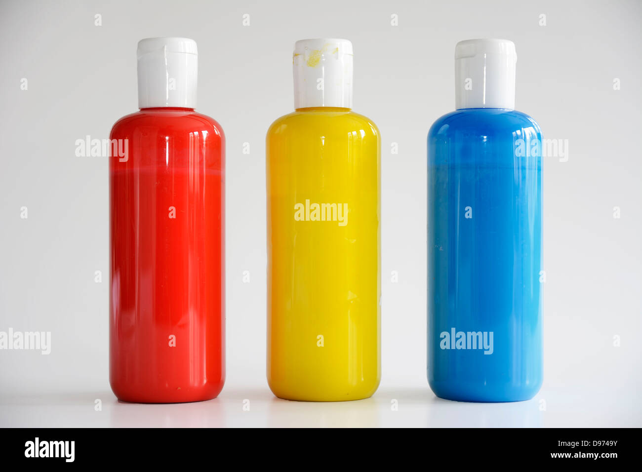 Rot, gelb, blau Flaschen auf grauem Hintergrund Stockfoto