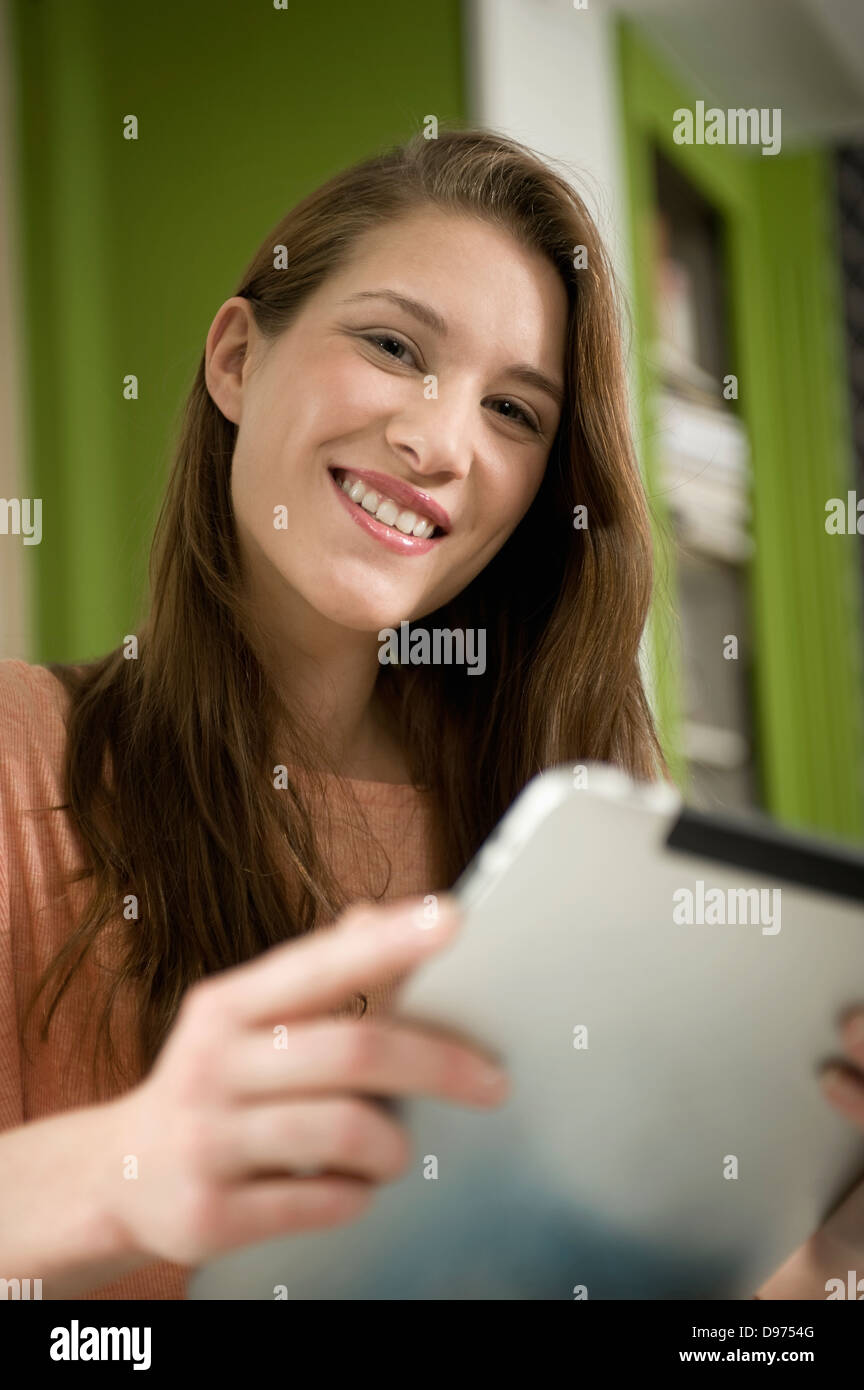 Deutschland, Bayern, München, Porträt der jungen Frau, die mit digital-Tablette, Lächeln Stockfoto