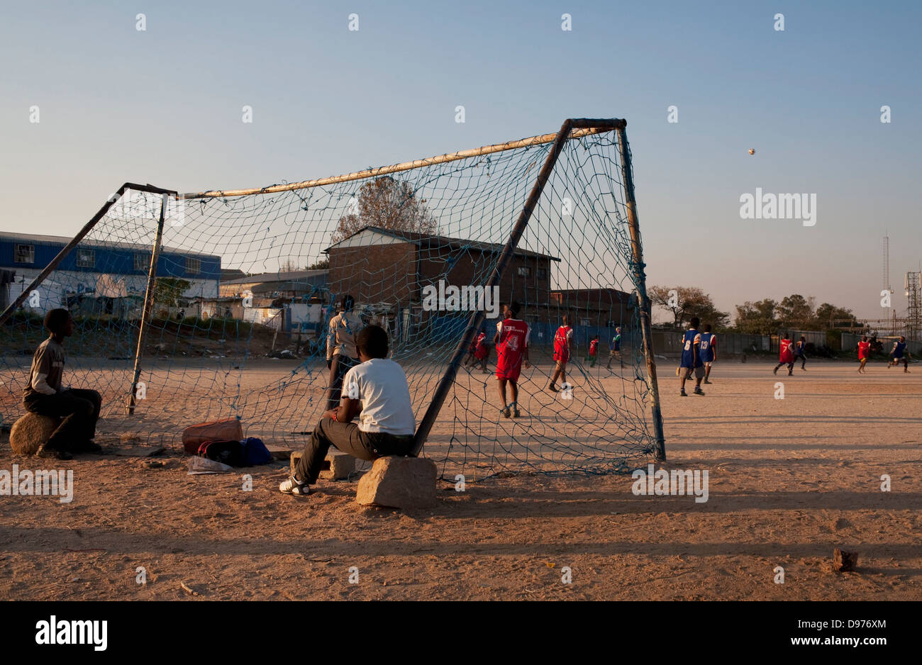 <p>Kinder spielen Fußball Fußballplatz neben alten Eisfabrik in Alexandra Township Johannesburg.</p> Stockfoto