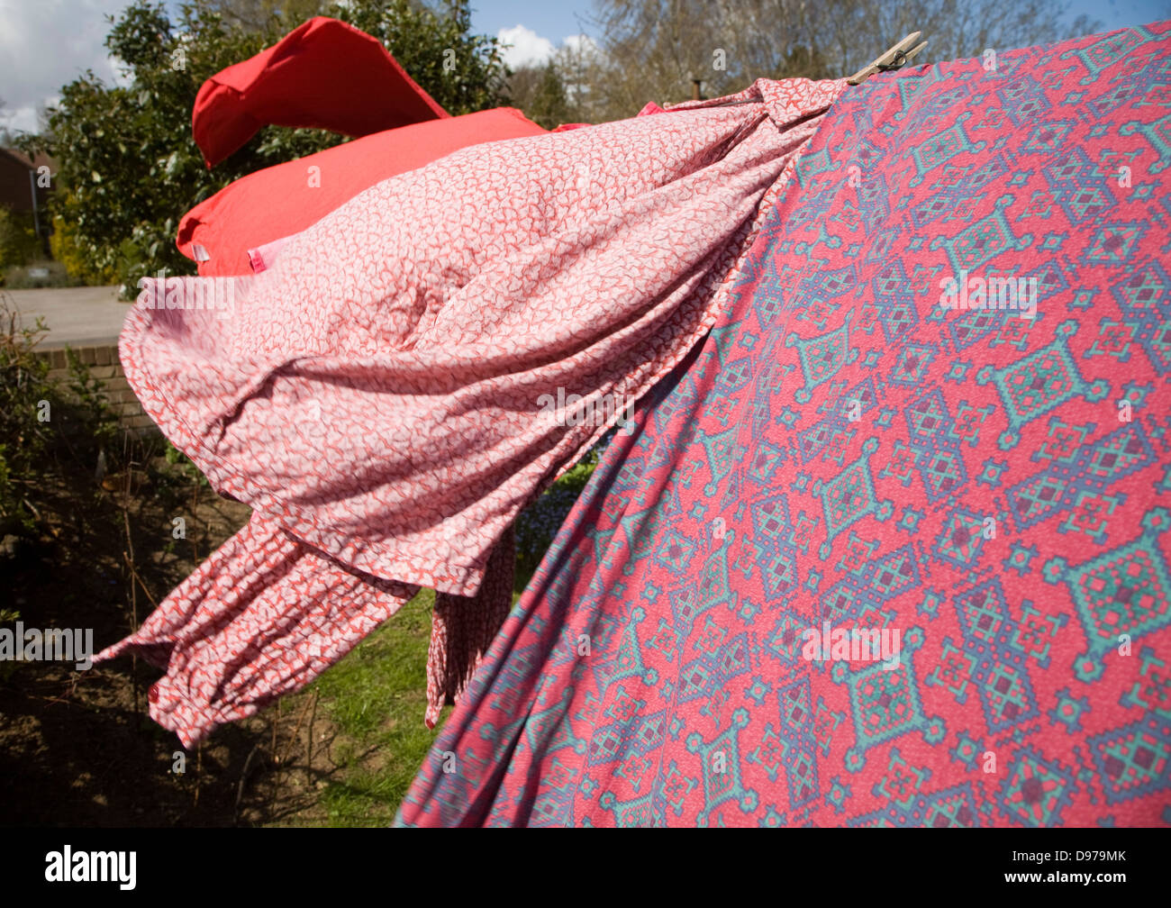 Rot rosa und lila Kleidung auf der Wäscheleine trocknen Stockfoto