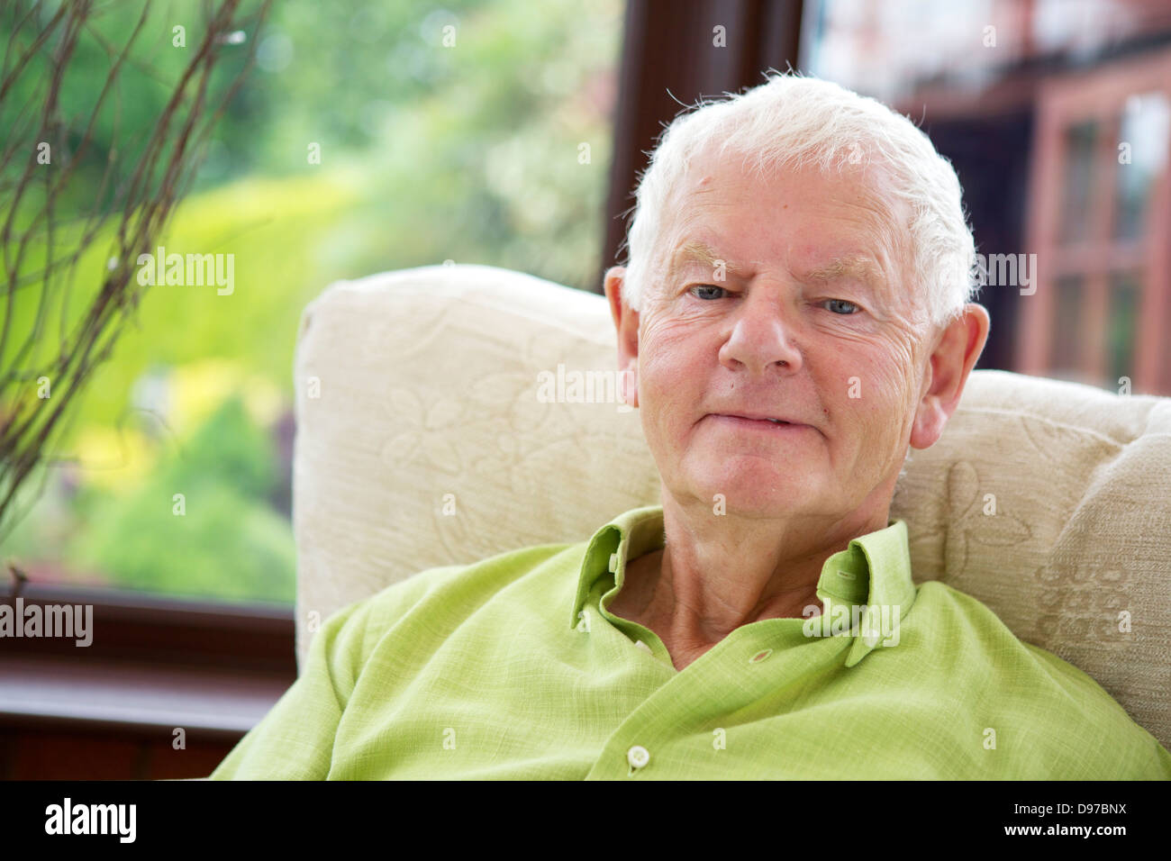 Siebziger Jahre Mann lächelnd in Kamera - im Ruhestand, glücklich und zufrieden Stockfoto