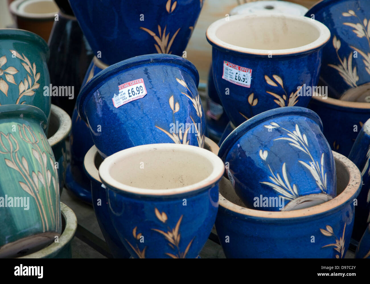 Bunte Keramik Töpfe häuften sich auf dem Display in einem Gartencenter, UK Stockfoto