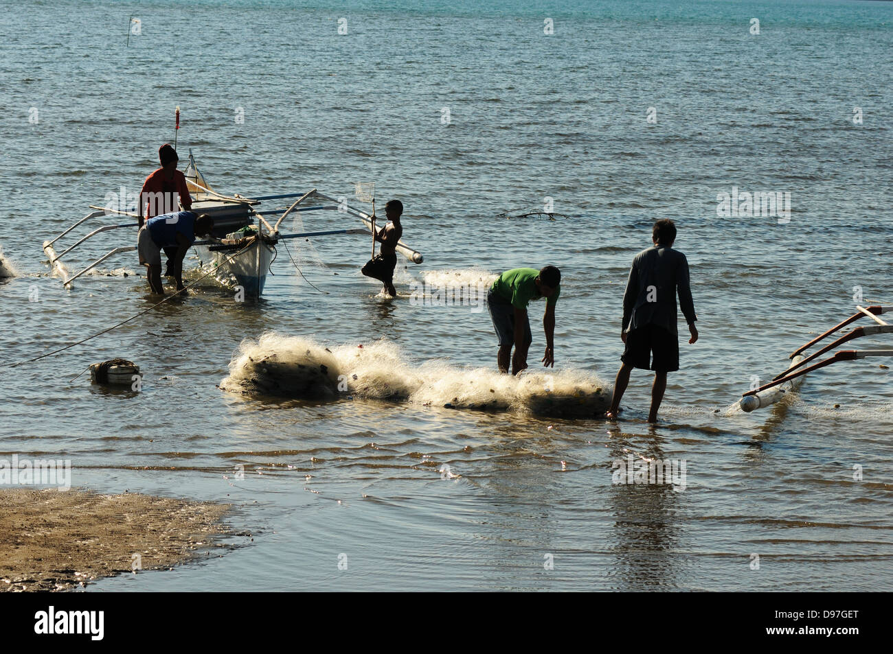 Fischer Netze vorzubereiten und Boot am Ufer des Bulalacao. Insel Mindoro, Philippinen Stockfoto