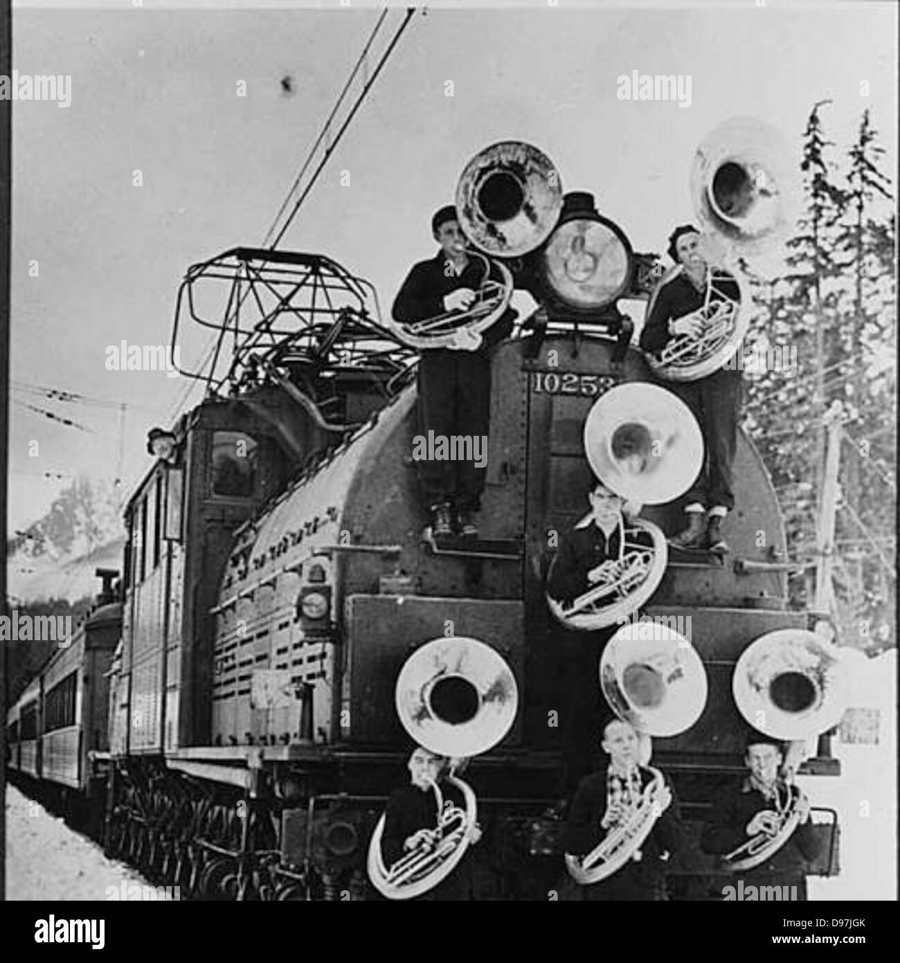 Die Bandmitglieder der Franklin High School posierten mit einer EP-2-Lokomotive der Milwaukee Road im Snoqualmie Pass, Washington, um einen Moment des Verkehrs und des Schulgeistes zu veranschaulichen. Stockfoto