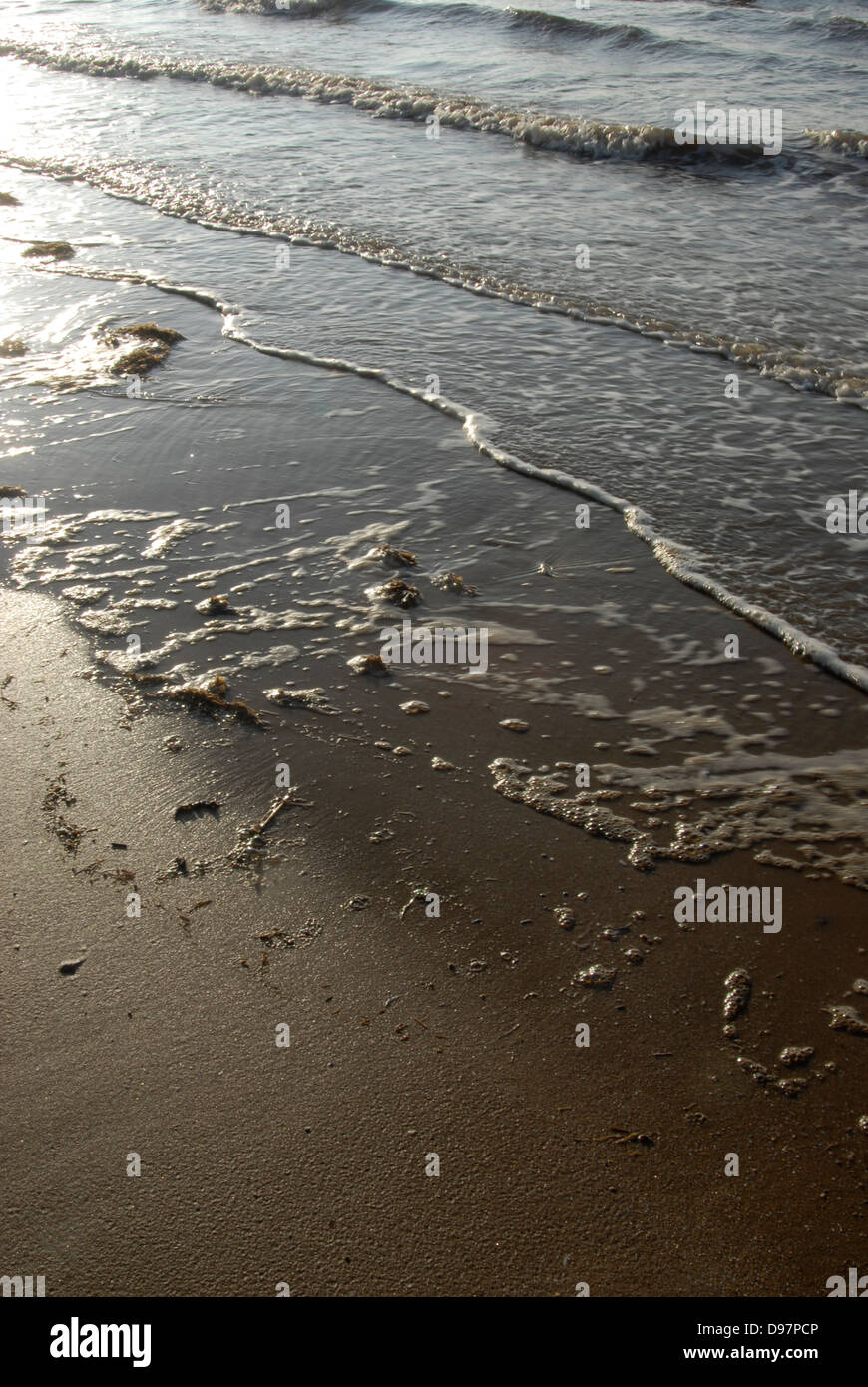 Flut kommt auf einem englischen Strand. Stockfoto