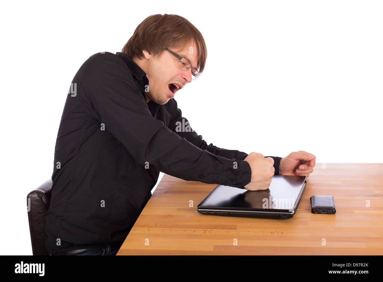 Verärgerter Mann schlagen mit der Faust auf seinem Laptop. Isoliert auf weißem Hintergrund. Stockfoto