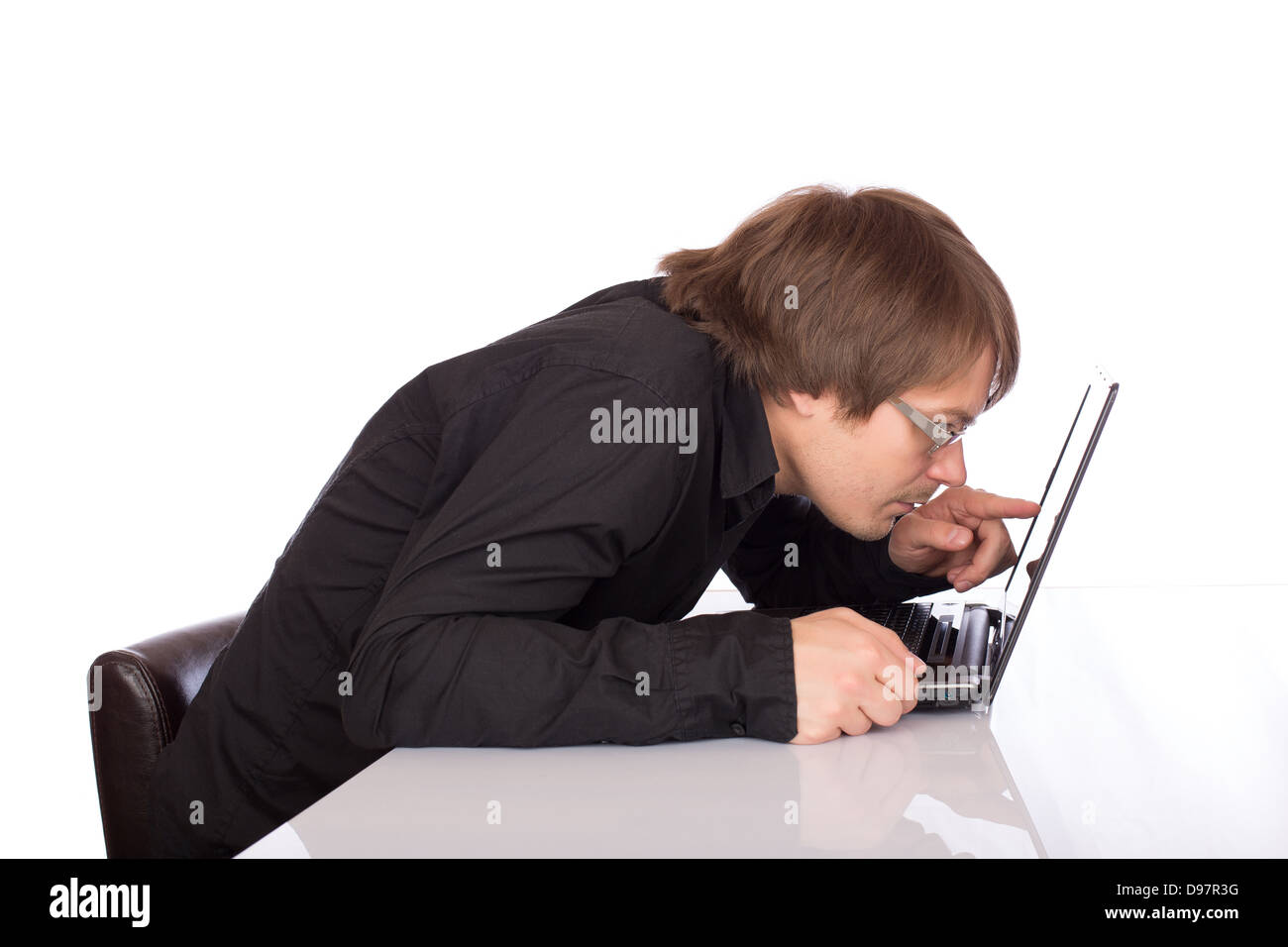 Verschlafene Geschäftsmann genauer seinen Laptop. Isoliert auf weißem Hintergrund. Stockfoto