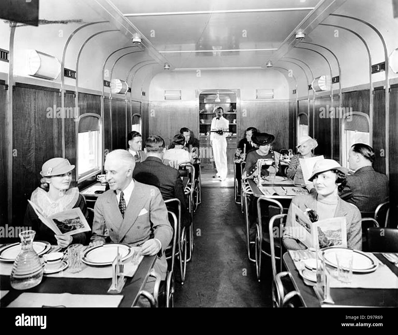 Dieses Bild zeigt das Innere eines Milwaukee Road Diner Car, das Teil der Chicago, Milwaukee, St. Paul und Pacific Railroad Company ist. Das Foto zeigt das Design von Speisewagen aus der Mitte des 20. Jahrhunderts und spiegelt den Luxus und Komfort wider, den die Passagiere während ihrer Reise bieten. Stockfoto