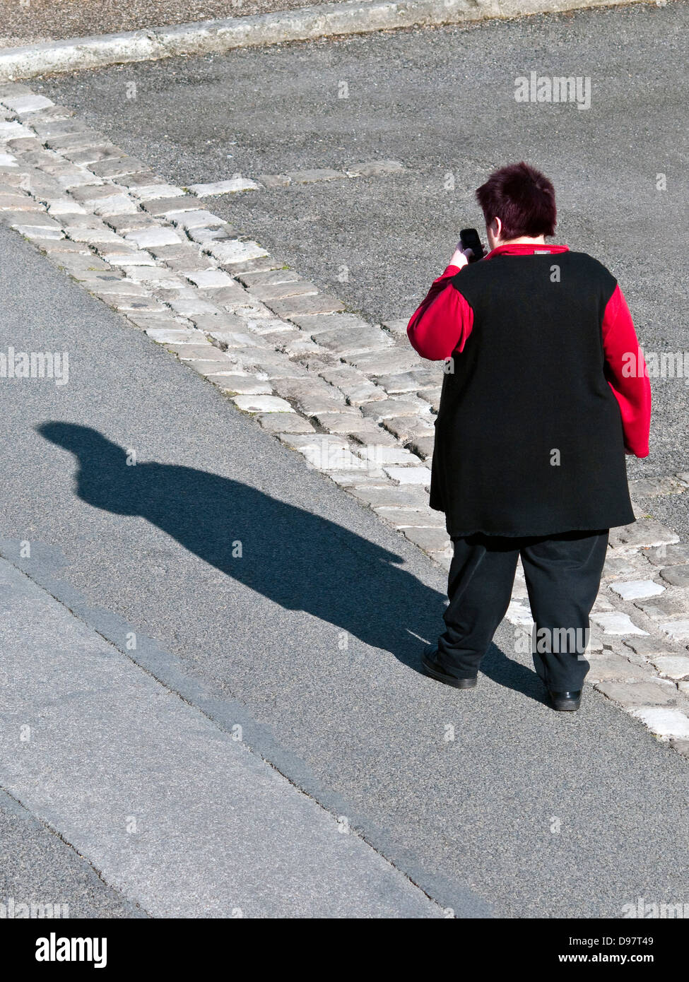 Draufsicht der übergewichtige Frau zu Fuß mit tragbaren Telefon - Frankreich. Stockfoto