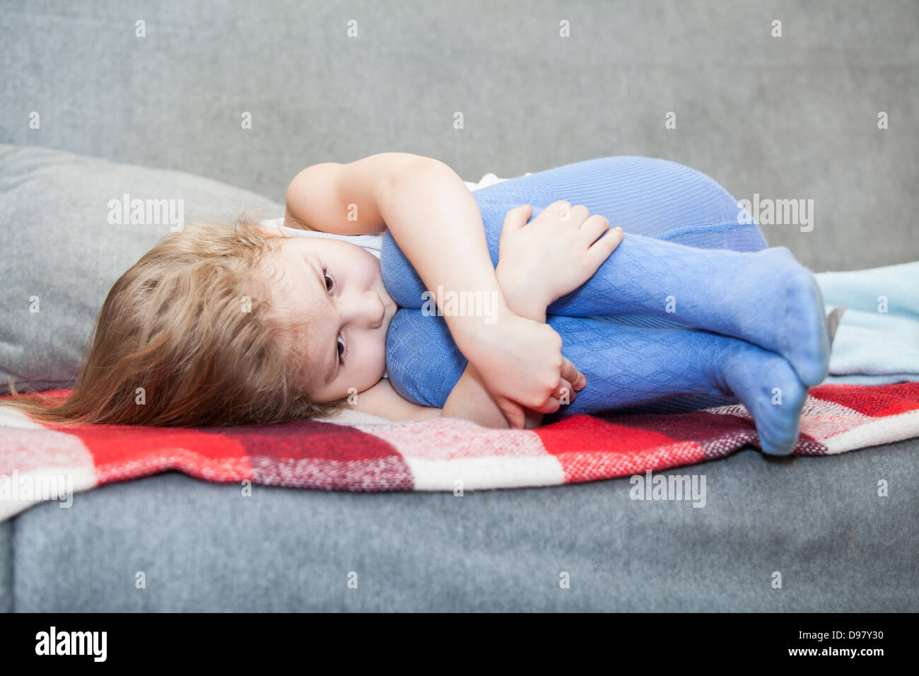 Kaukasische wehrlos Kleinkind drängten sich auf der couch Stockfoto