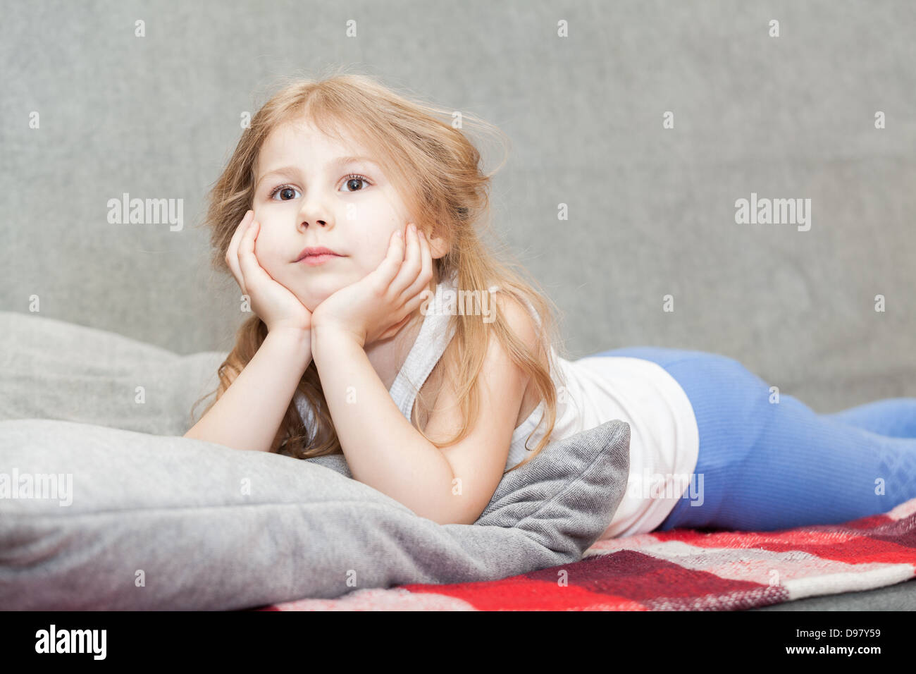 Wenig kaukasische Mädchen träumen auf der Couch liegen Stockfoto