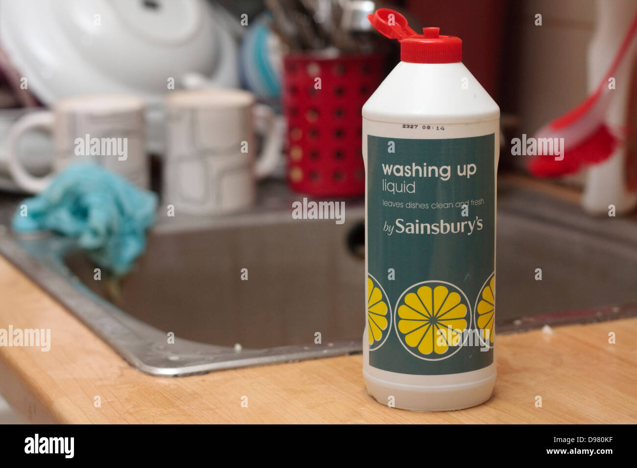 Eine Flasche von Sainsburys Marke Spülmittel vor unübersichtlich und chaotisch Waschbecken Stockfoto