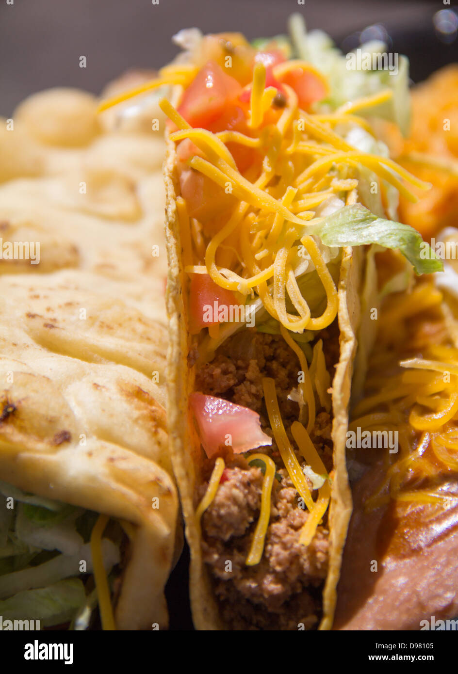 Fast-Food-Taco eingebettet zwischen einem Fladenbrot Taco und gebackenen Bohnen Stockfoto