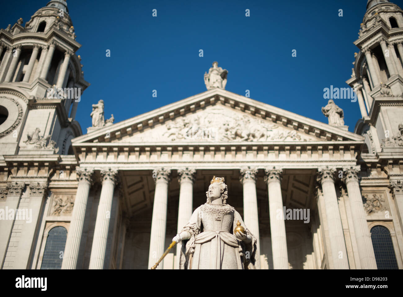 Queen Victoria Statue St Paul's Cathedral London // LONDON, Großbritannien – die Statue von Queen Victoria steht prominent vor der St Paul's Cathedral, einem der markantesten Wahrzeichen Londons. Das Denkmal wurde von Thomas Brock geschaffen und 1886 anlässlich des Goldenen Jubiläums der Königin enthüllt. Es zeigt Victoria in voller königlicher Kleidung, in kaiserlichen Gewändern und Diamantkrone. Sie hält ein vergoldetes Zepter in der rechten Hand und eine Herrschaftsorbe in der linken, traditionelle Symbole der königlichen Autorität. Die Statue befindet sich auf einem Granitsockel, umgeben von vier allegorischen Figuren, die darstellen Stockfoto