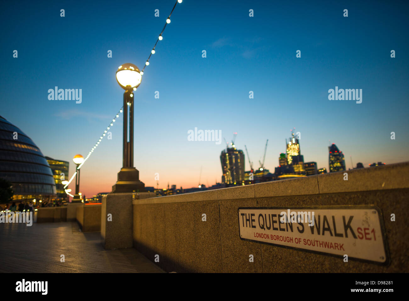 LONDON, GROSSBRITANNIEN - Die Königinnen im Londoner Stadtteil Southwark entfernt, in der Nähe der Tower Bridge, in der Dämmerung, mit der die Lichter der Stadt in der Innenstadt von London im Hintergrund. Stockfoto