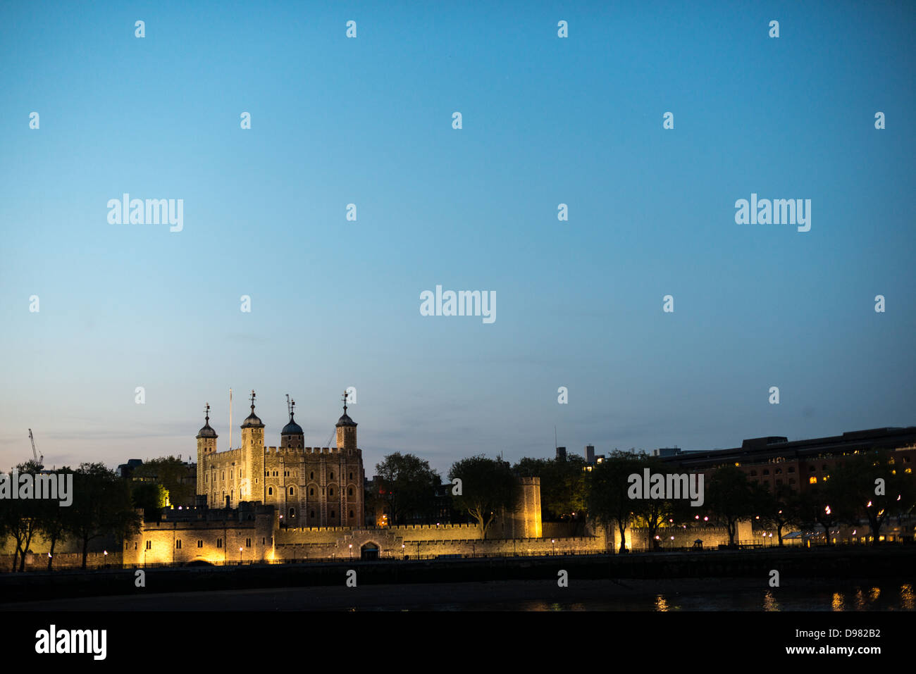 Tower of London beleuchtet in der Abenddämmerung London England // der Tower of London beleuchtet von Lichtern gegen den Abenddämmerhimmel, vom südlichen Ufer der Themse aus gesehen. Mit Copyspace. Stockfoto